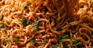 Bowl of easy garlic chili oil noodles garnished with fresh herbs