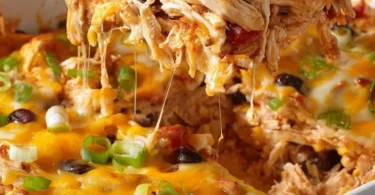 Healthy chicken taco casserole topped with fresh ingredients and cheese.