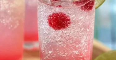 Delicious Raspberry Key Lime Soda in a glass with ice and lime slices