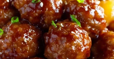 Slow cooker teriyaki meatballs served in a bowl with sauce and garnishes.